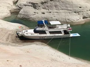 Slide: The Image of 1981 Blue Water Coastal Cruiser moored in a rocky cove with clear green water. - 1