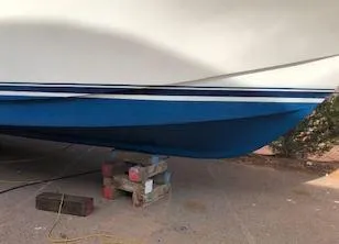 Slide: The Image of 1981 Blue Water Coastal Cruiser boat hull on blocks, showcasing blue and white design. - 14