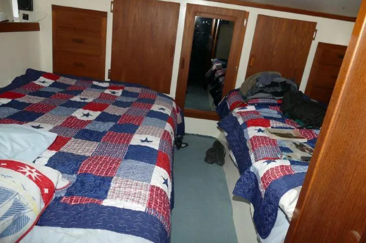 Slide: The Image of Interior of 1981 Blue Water Coastal Cruiser with twin beds and colorful patchwork quilts. - 2