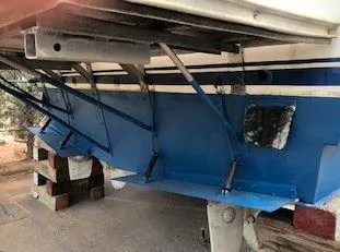 Slide: The Image of 1981 Blue Water Coastal Cruiser boat hull on blocks, showing underside and support structures. - 3