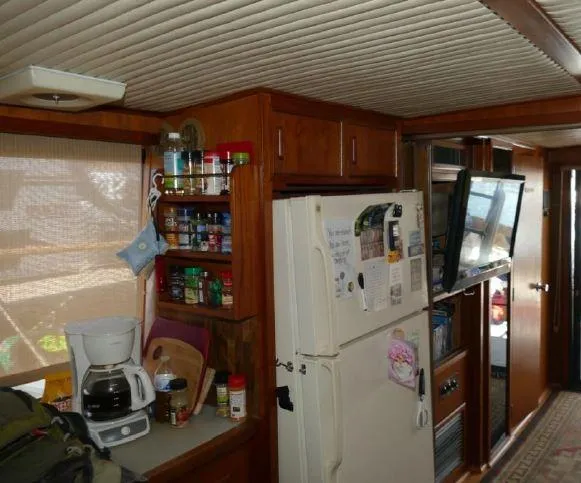 Slide: The Image of 1981 Blue Water Coastal Cruiser interior with kitchen, refrigerator, spice rack, and TV. - 4