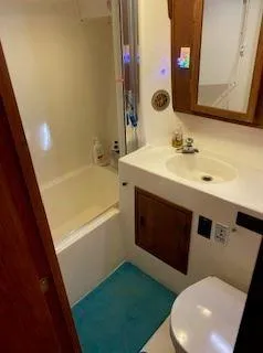 Slide: The Image of 1981 Blue Water Coastal Cruiser bathroom with sink, toilet, and shower. - 6