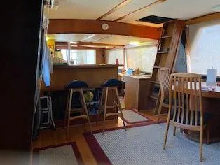Slide: The Image of Interior of 1981 Blue Water Coastal Cruiser with wooden furniture and bar stools. - 9