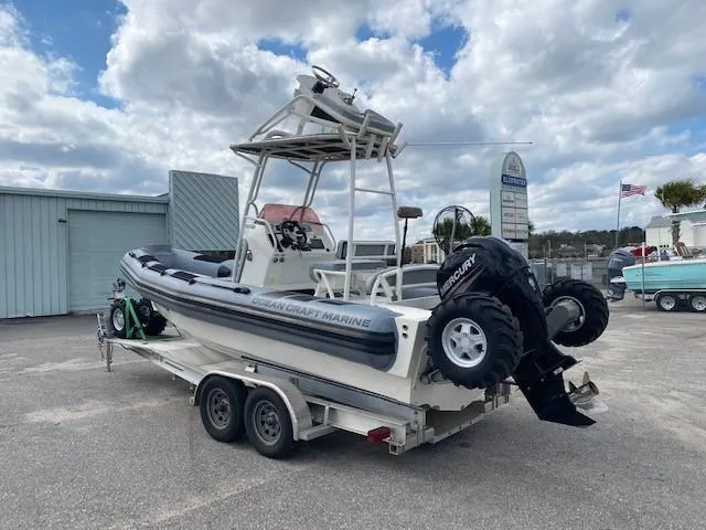 Slide: The Image of 2020 Ocean Craft Marine 24 boat on trailer, featuring Mercury outboard motor. - 2