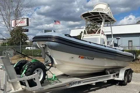 Slide: The Image of 2020 Ocean Craft Marine 24 boat on trailer, parked outdoors under cloudy sky. - 8
