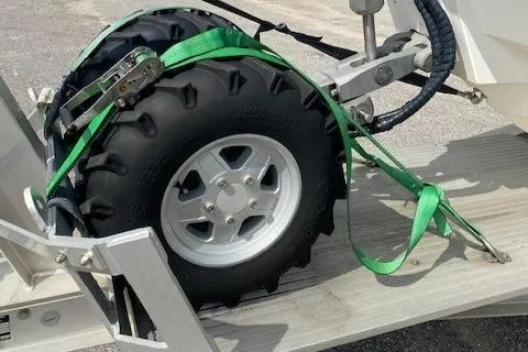 Slide: The Image of Close-up of a 2020 Ocean Craft Marine 24 trailer wheel secured with green straps. - 9