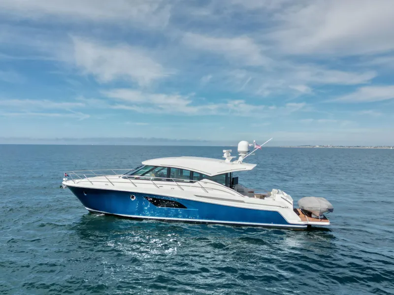 Slide: The Image of 2022 Tiara Yachts 53 Coupe cruising on open water under a clear sky. - 11