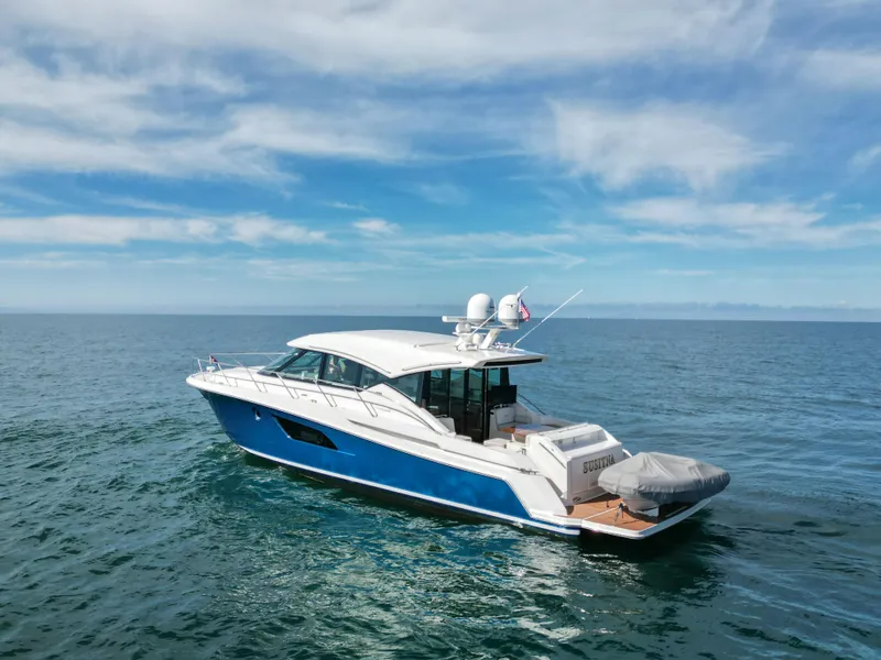 Slide: The Image of 2022 Tiara Yachts 53 Coupe cruising on open water under a clear sky. - 12