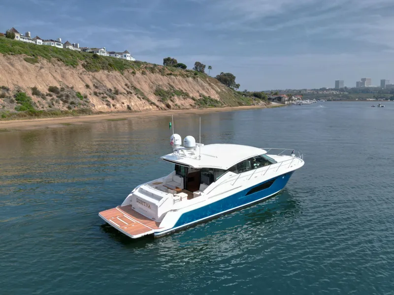Slide: The Image of 2022 Tiara Yachts 53 Coupe cruising near scenic coastal cliffs. - 15