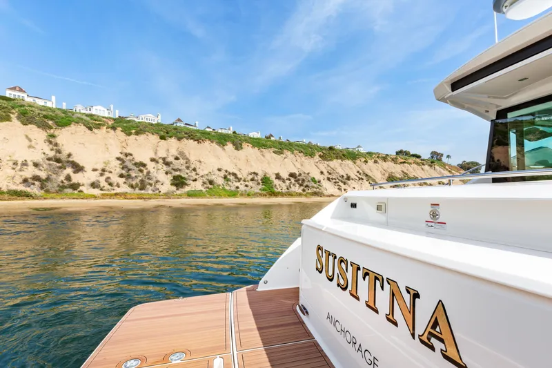 Slide: The Image of 2022 Tiara Yachts 53 Coupe near scenic coastal cliffs. - 18