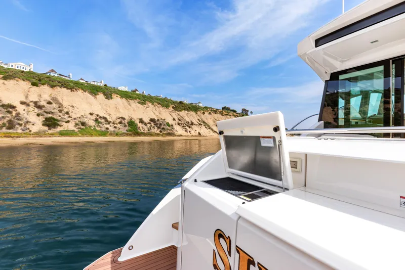 Slide: The Image of Tiara Yachts 2022 53 Coupe near scenic coastline under blue sky. - 20