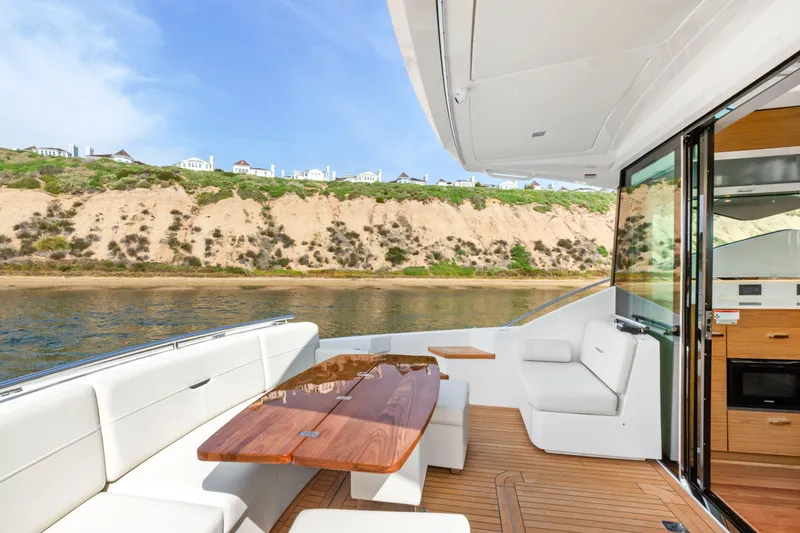 Slide: The Image of Luxurious 2022 Tiara Yachts 53 Coupe with elegant outdoor seating and scenic coastal view. - 23