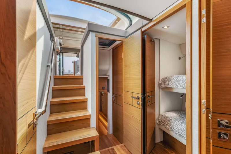 Slide: The Image of Interior of 2022 Tiara Yachts 53 Coupe with wooden stairs and cozy bunk beds. - 38