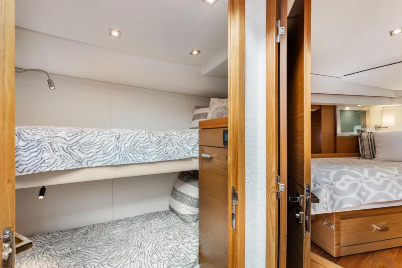 Slide: The Image of Interior of 2022 Tiara Yachts 53 Coupe with cozy bunk beds and elegant wood finishes. - 43