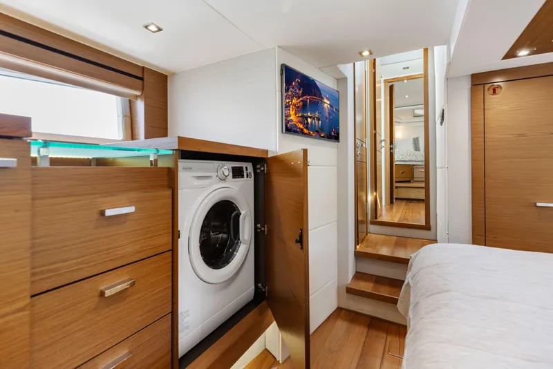 Slide: The Image of Luxurious 2022 Tiara Yachts 53 Coupe interior with washer, wood cabinetry, and modern design. - 46