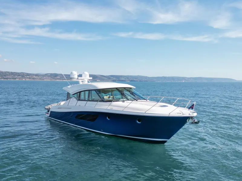 Slide: The Image of 2022 Tiara Yachts 53 Coupe cruising on open water under a clear sky. - 5