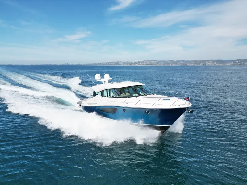 Slide: The Image of 2022 Tiara Yachts 53 Coupe cruising on open water under a clear blue sky. - 9