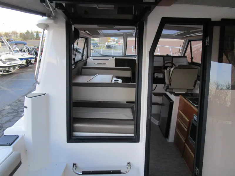 Slide: The Image of 2024 Cutwater C-288 C interior seating with table and cup holders. - 29