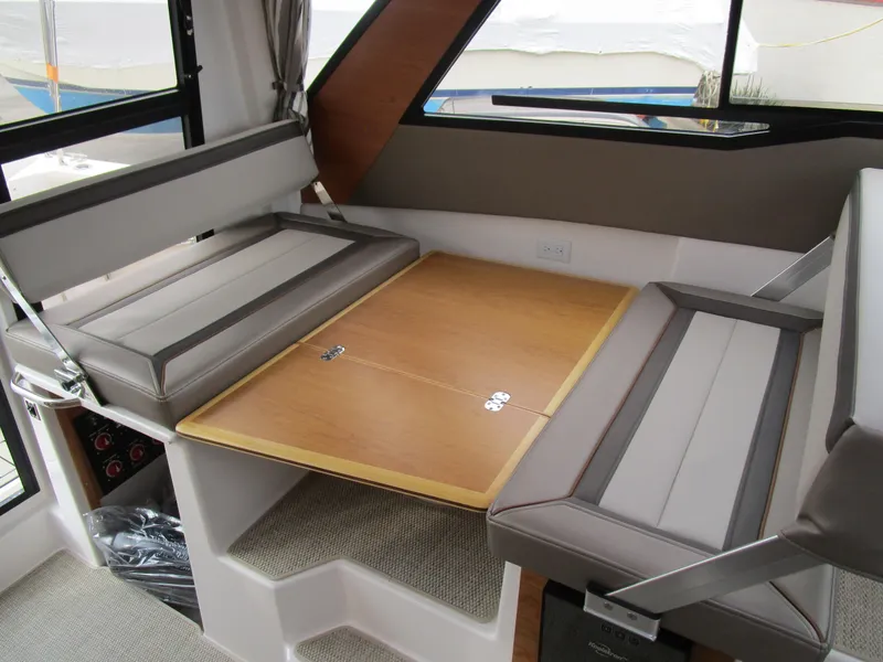 Slide: The Image of 2024 Cutwater C-288 C interior with TV, seating, and wooden cabinetry. - 34