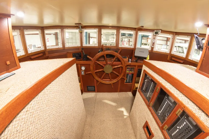 Slide: The Image of Interior helm of 1993 Custom Steel Trawler with wooden steering wheel and navigation equipment. - 15