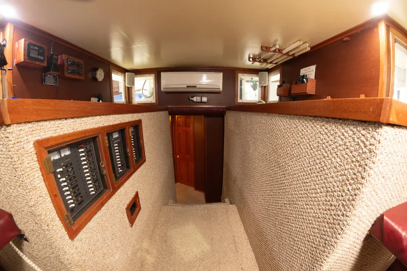 Slide: The Image of Interior of a 1993 Custom Steel Trawler with control panels and carpeted walls. - 16