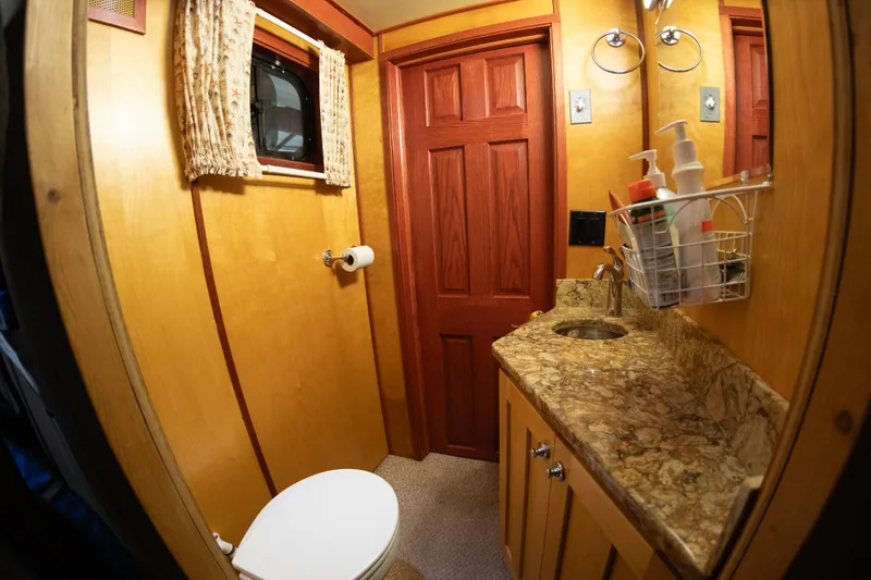 Slide: The Image of 1993 Custom Steel Trawler bathroom with wooden cabinetry and granite countertop. - 18