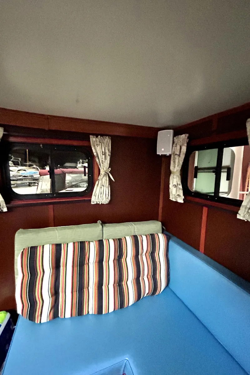 Slide: The Image of 1993 Custom Steel Trawler interior with blue seating and striped cushions. - 19
