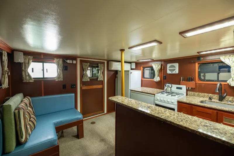 Slide: The Image of 1993 Custom Steel Trawler interior with kitchen and seating area. - 24