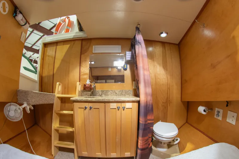Slide: The Image of 1993 Custom Steel Trawler interior with wooden cabinetry and compact bathroom. - 25