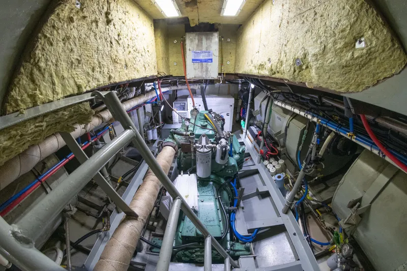 Slide: The Image of Engine room of a 1993 Custom Steel Trawler with visible machinery and insulation. - 39