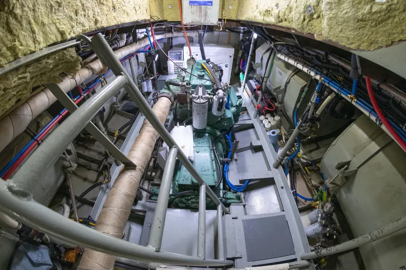 Slide: The Image of Engine room of a 1993 Custom Steel Trawler with visible machinery and wiring. - 41