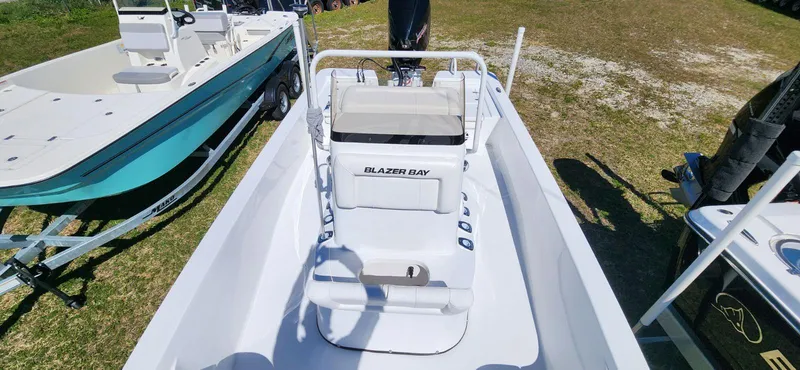 Slide: The Image of 2024 Blazer 2220 Fisherman boat, white interior, parked on grass. - 4