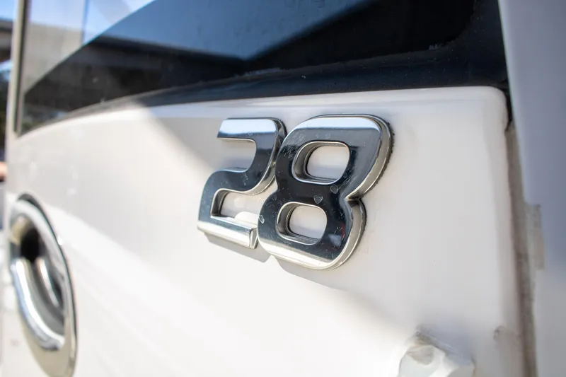 Slide: The Image of 2021 Regulator 28 boat emblem in shiny chrome on white surface. - 15