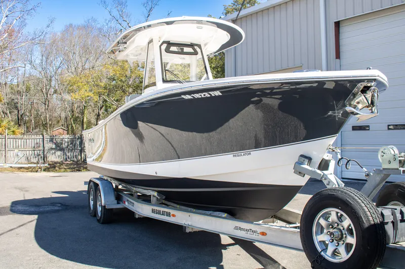Slide: The Image of 2021 Regulator 28 boat on trailer, parked outdoors near a building. - 2