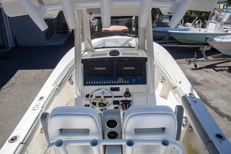 Slide: The Image of 2021 Regulator 28 boat cockpit with dual Garmin displays and white seating. - 21