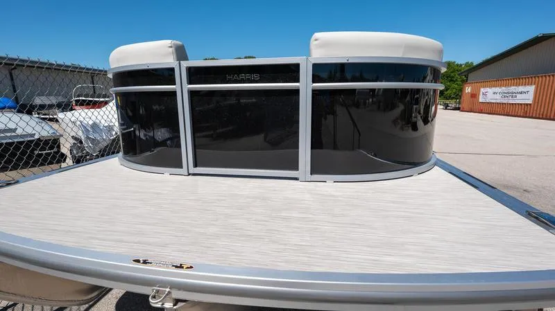 Slide: The Image of 2024 Harris 230 Breeze pontoon boat, docked in a marina under clear blue skies. - 10