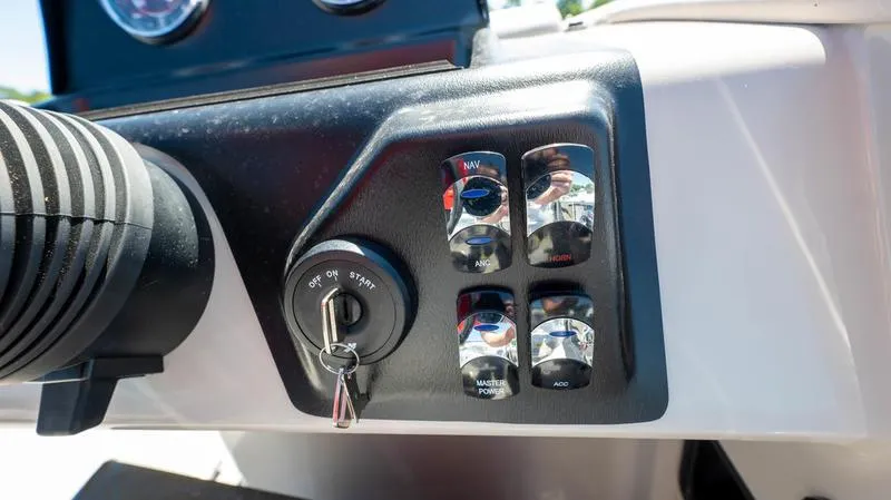 Slide: The Image of 2024 Harris 230 Breeze boat dashboard with ignition key and control switches. - 20