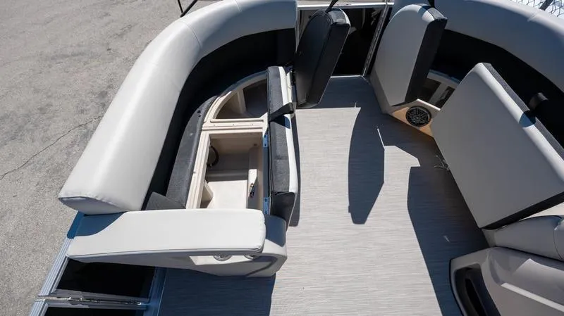 Slide: The Image of 2024 Harris 230 Breeze boat interior with open storage compartments and cushioned seating. - 21
