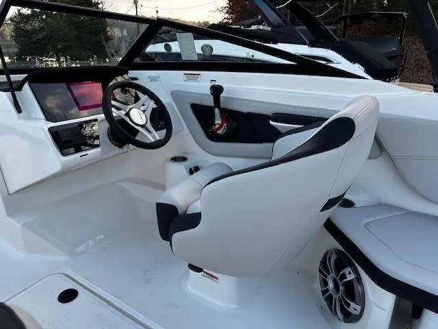 Slide: The Image of 2024 Sea Ray SPX 210 Outboard boat interior with sleek white seating and modern dashboard. - 7