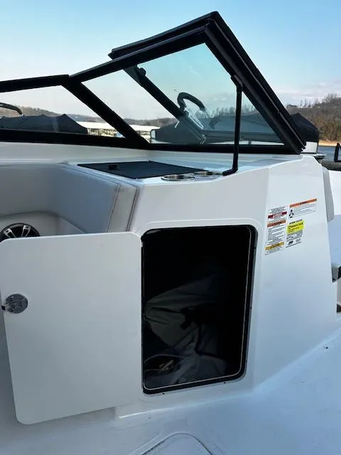 Slide: The Image of 2024 Sea Ray SPX 210 Outboard boat interior storage compartment with open door. - 9