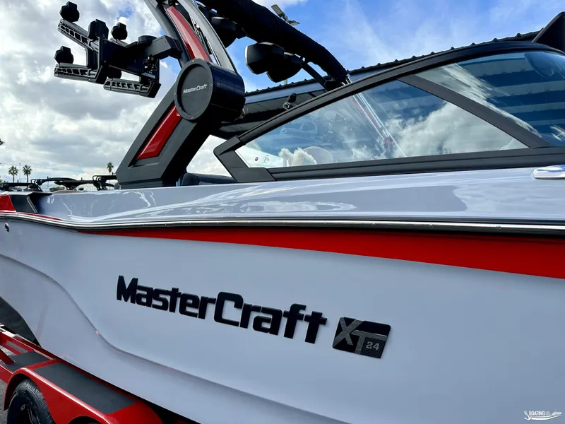 Slide: The Image of 2024 MasterCraft XT24 boat with sleek design and modern features against a cloudy sky. - 1