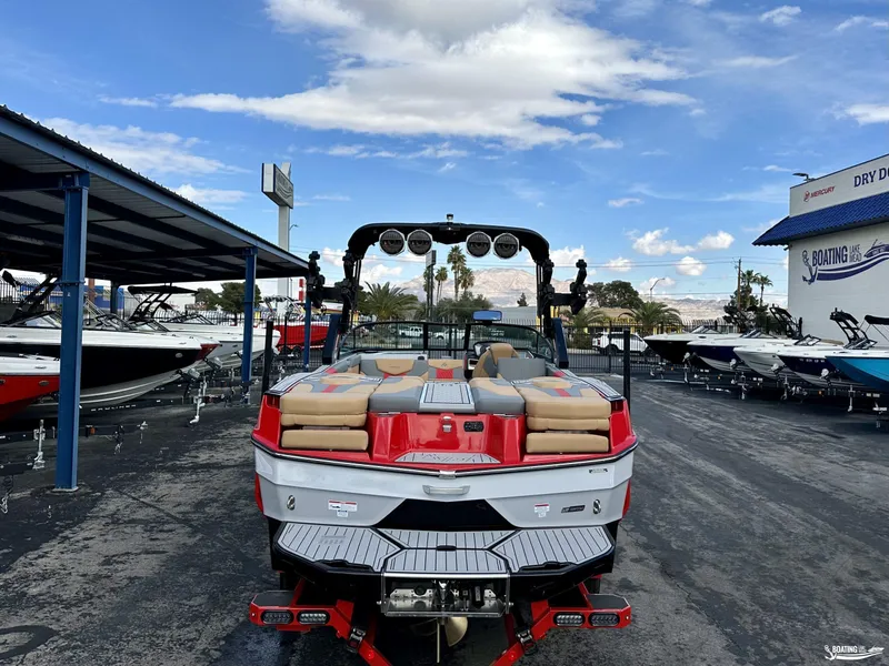Slide: The Image of 2024 MasterCraft XT24 boat in dealership lot under blue sky. - 3