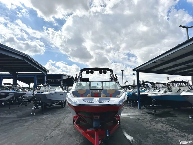 Slide: The Image of 2024 MasterCraft XT24 boat displayed in a marina under a cloudy sky. - 4