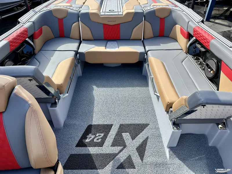 Slide: The Image of 2024 MasterCraft XT24 boat interior with gray, red, and tan seating. - 7