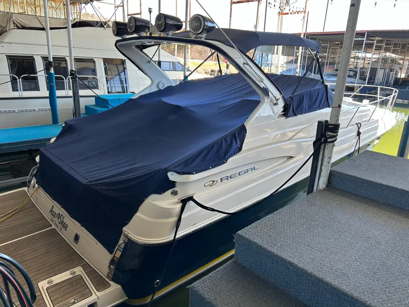 Slide: The Image of 2004 Regal Commodore 3560 IO boat docked with blue cover and canopy. - 11