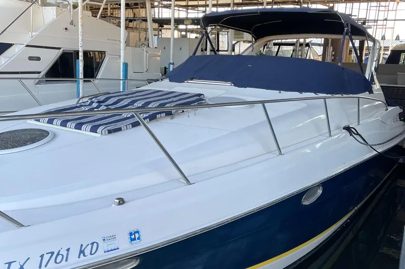 Slide: The Image of 2004 Regal Commodore 3560 IO yacht docked in marina, featuring sleek design and blue accents. - 12