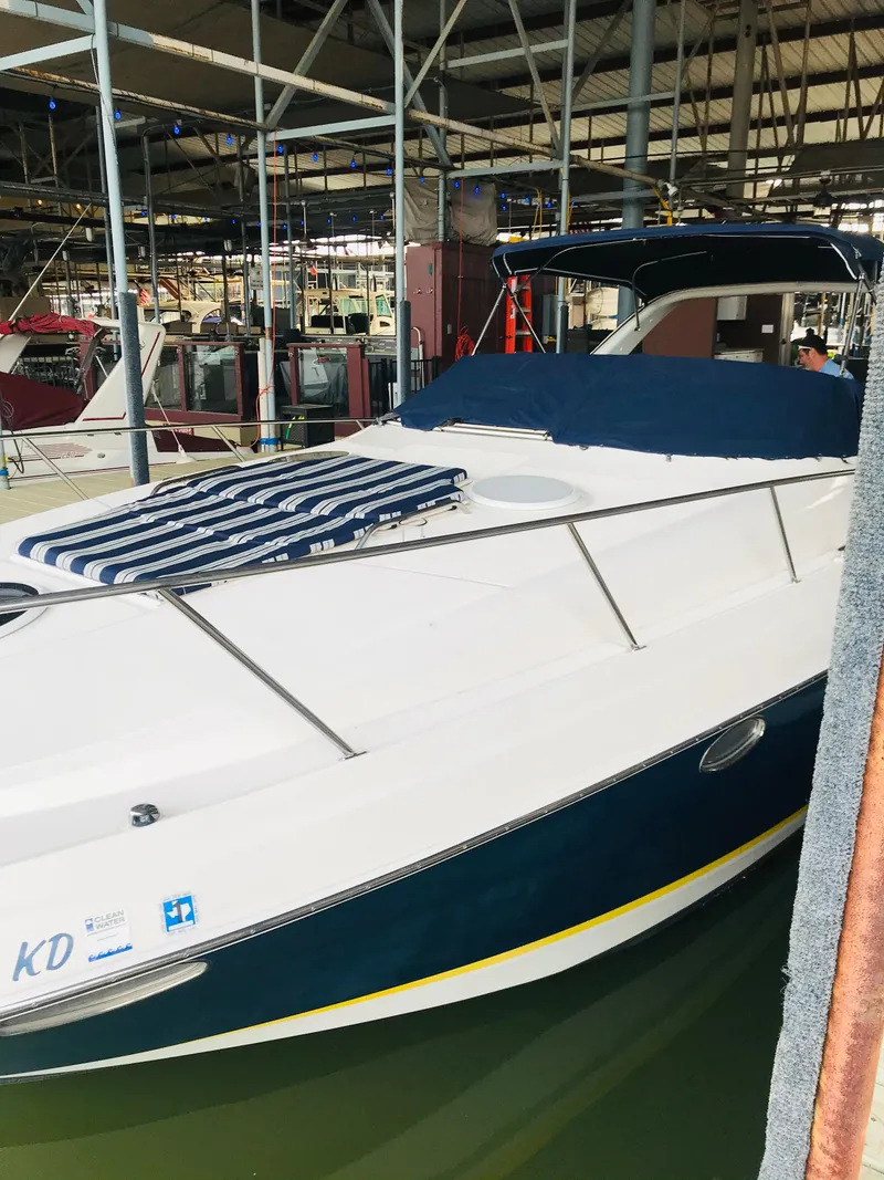 Slide: The Image of 2004 Regal Commodore 3560 IO boat docked in a marina, featuring a sleek design and blue accents. - 4
