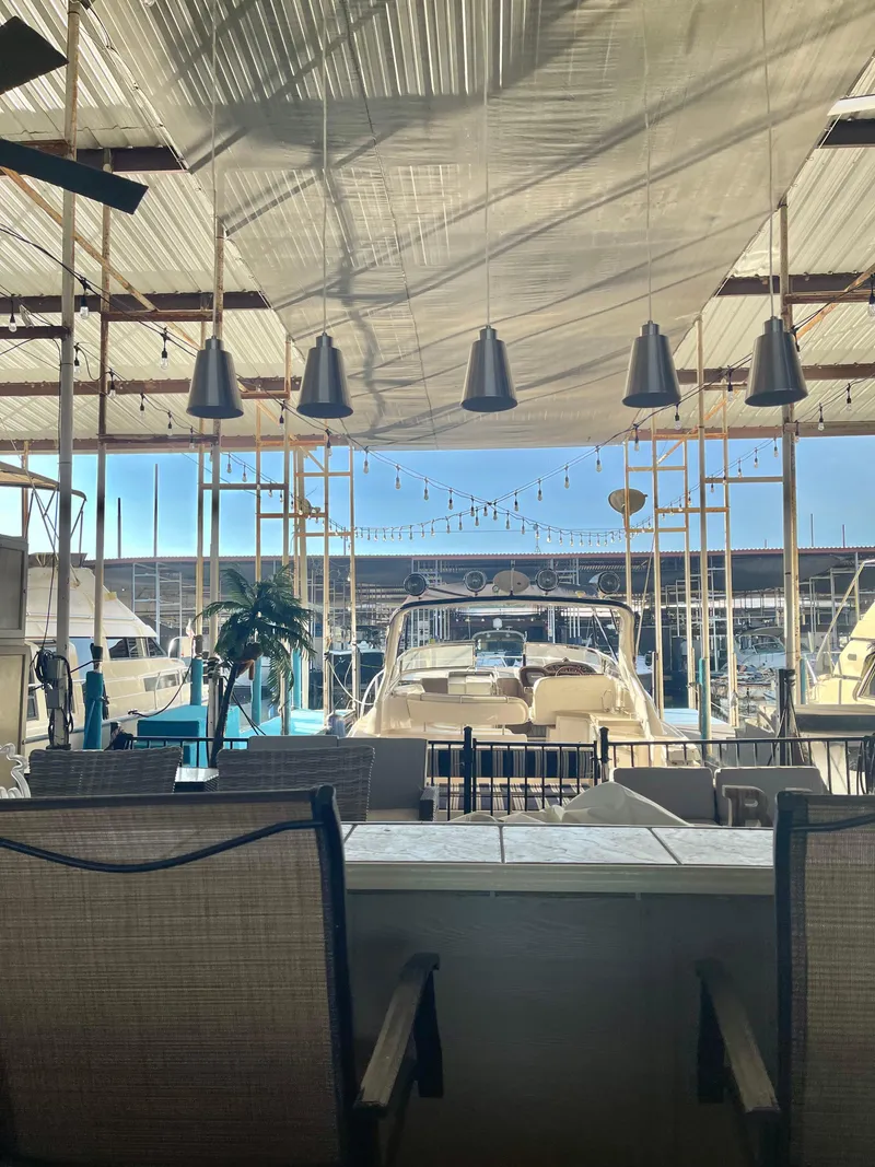 Slide: The Image of 2004 Regal Commodore 3560 IO yacht docked under canopy with seating area. - 5