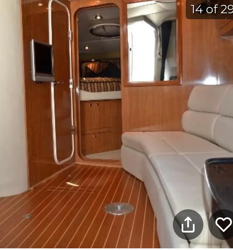 Slide: The Image of 2004 Regal Commodore 3560 IO interior with wood paneling and white seating. - 8