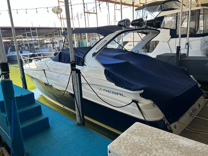 Slide: The Image of 2004 Regal Commodore 3560 IO boat docked, covered with blue canvas, in a marina setting. - 9